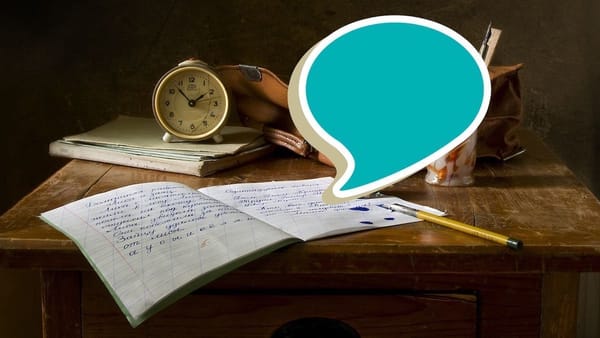 speech bubble superimposed on old-style desk with student's composition notebook with fountain pen and pencil