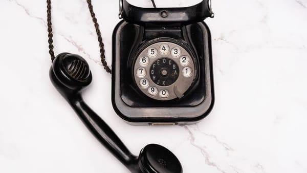 old-style black rotary telephone with curly cord