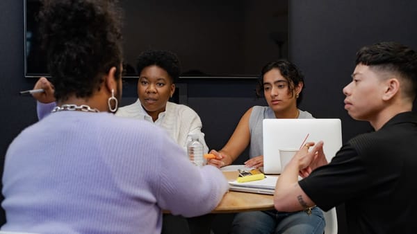 coworkers sitting at a table having a meeting